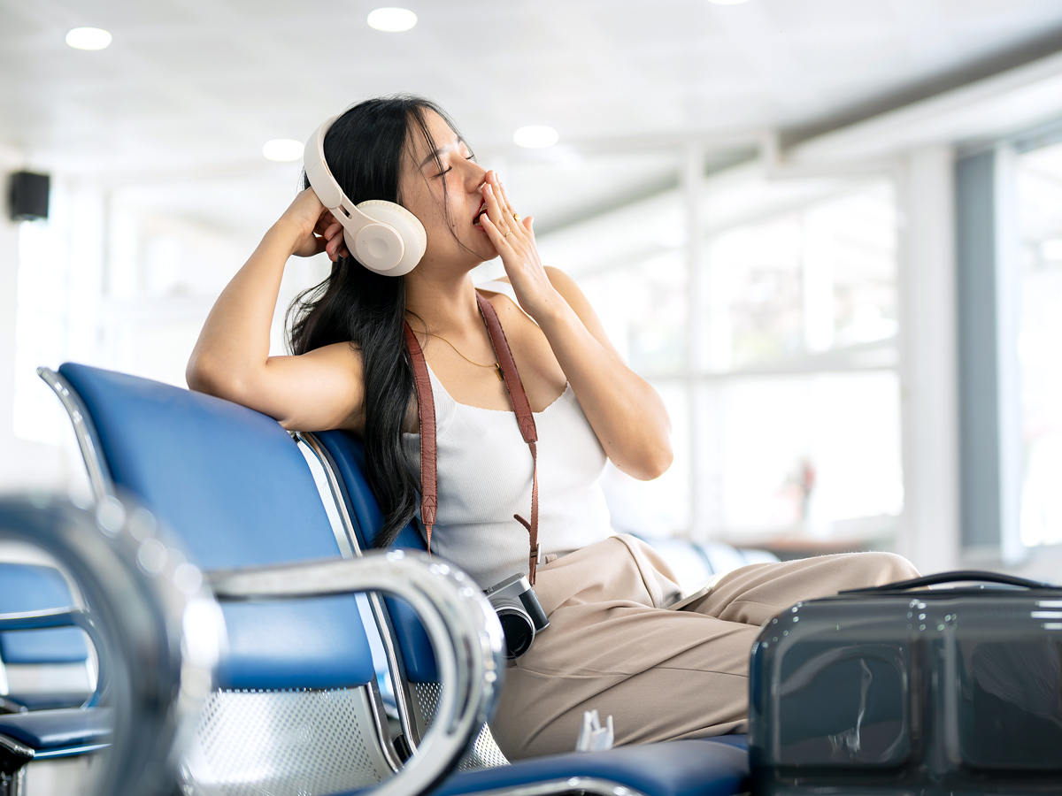 A woman is yawning while waiting to board