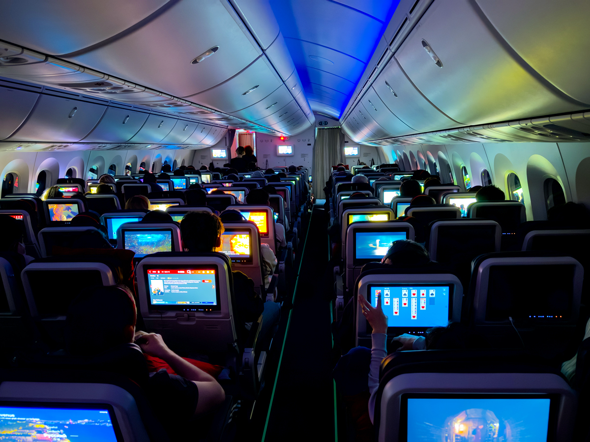 Passengers on a plane watch in-flight movies