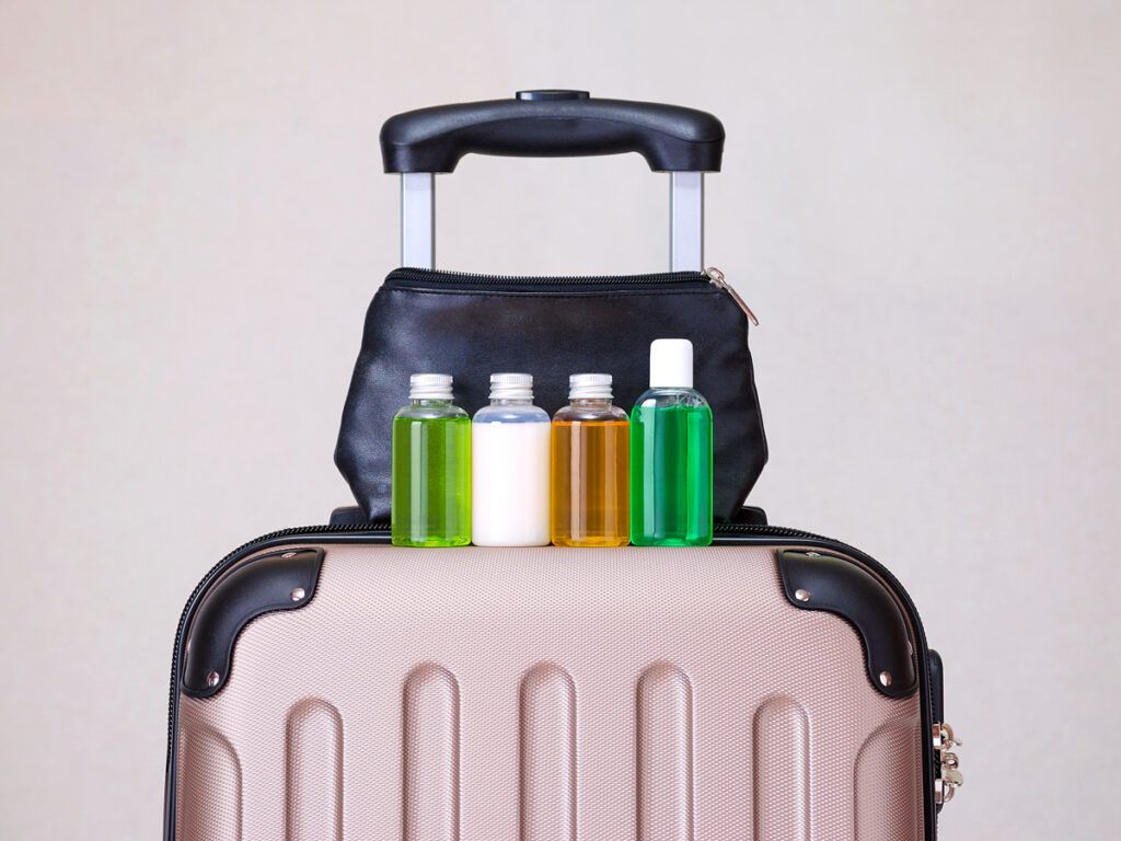 Travel-sized toiletries on top of suitcase