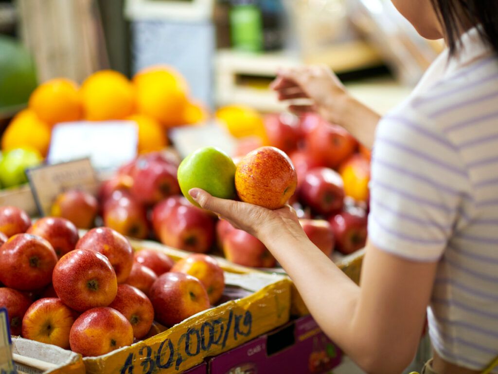 Woman selecting apples at the grocery store