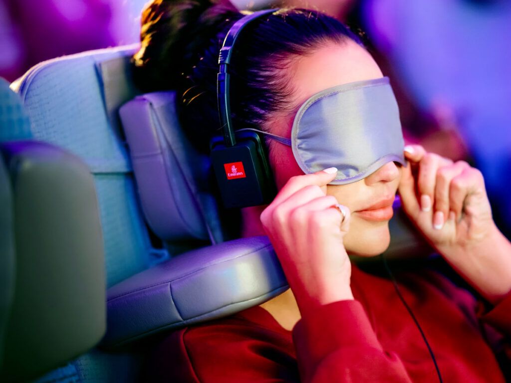 Woman using Emirates' new travel pillow headrest