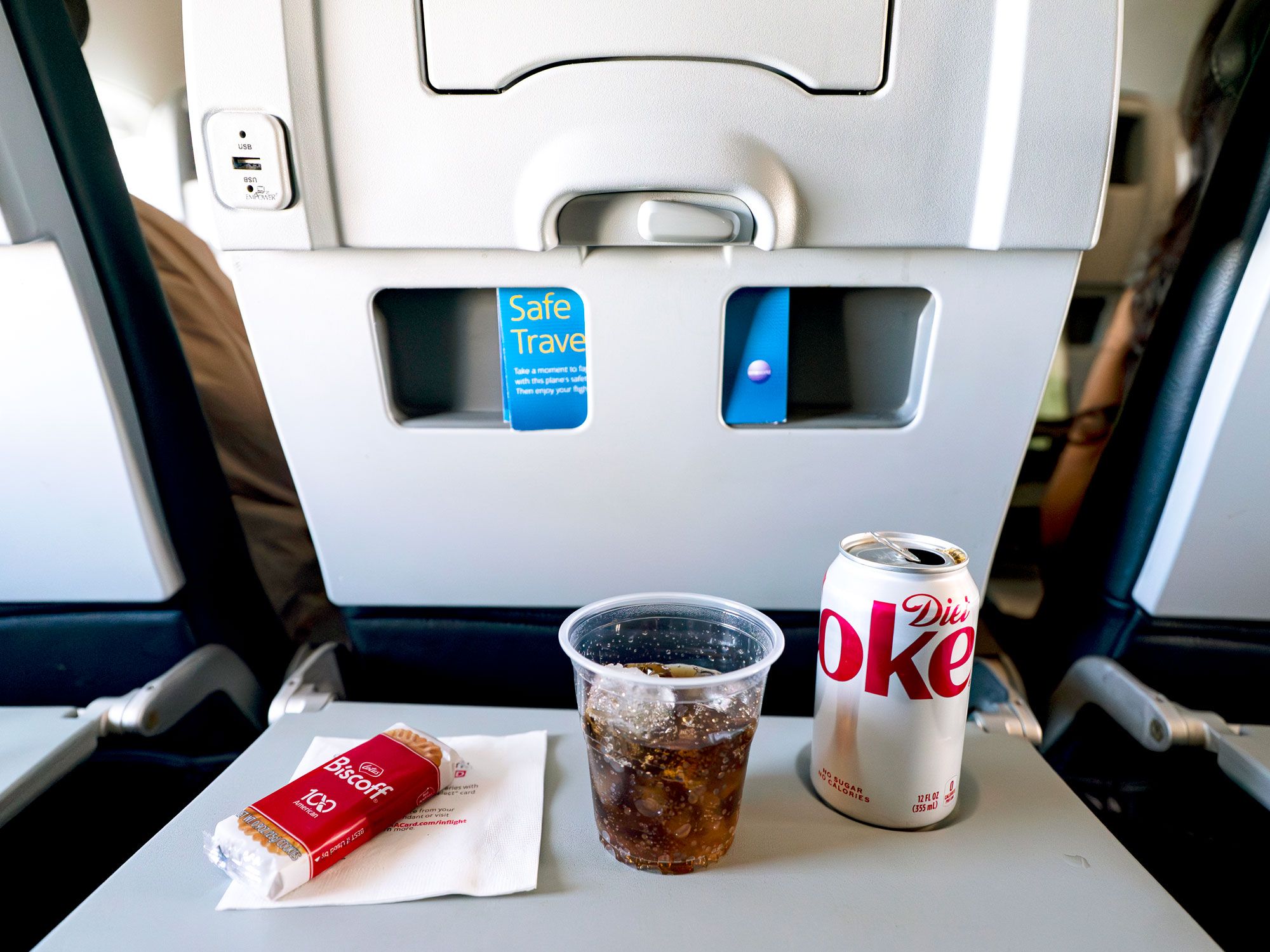 Diet Coke and Biscoff cookie on plane tray table