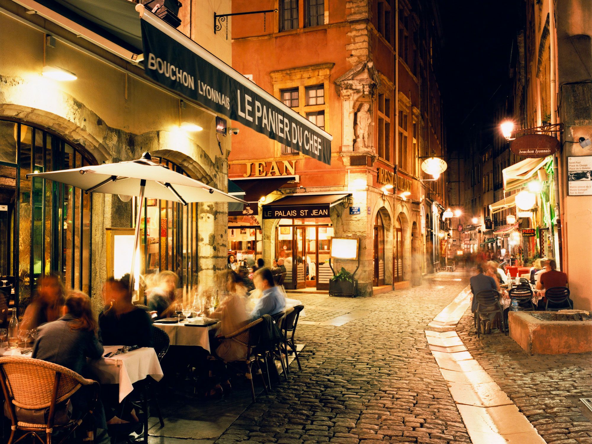 People dining outdoors at night in Lyon, France