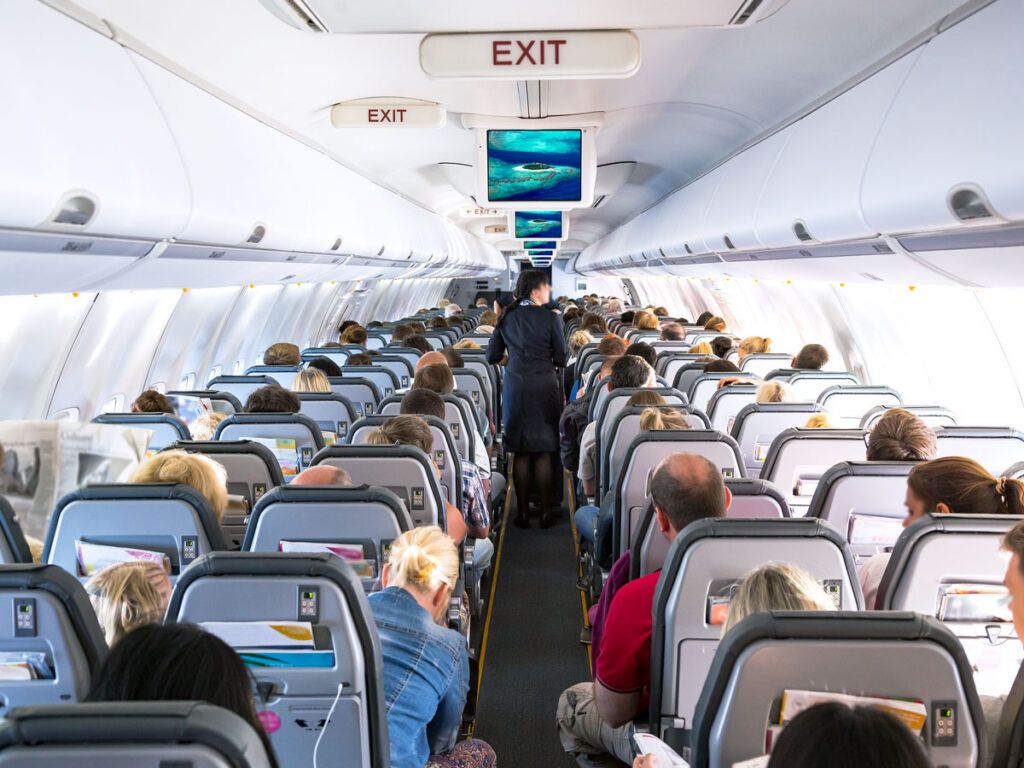 Aisle lined with passengers aboard a flight