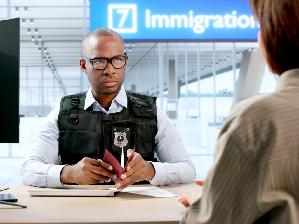 Woman hands her passport to a border control officer