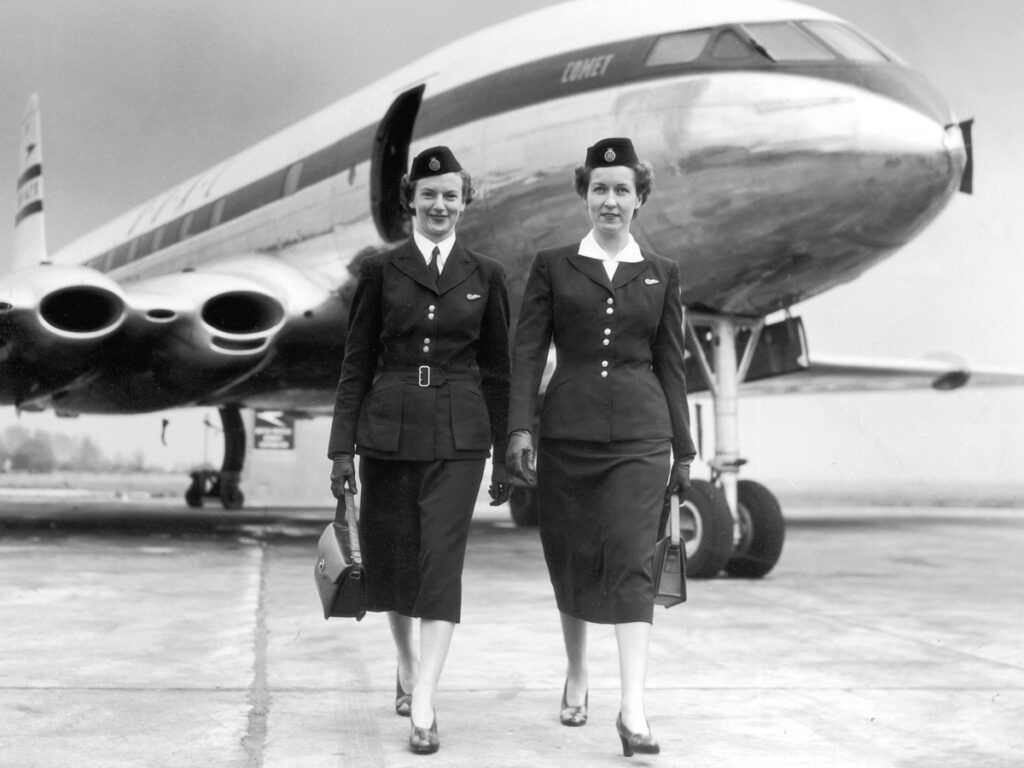 Two flight attendants walking away from a BOAC Comet, circa 1950