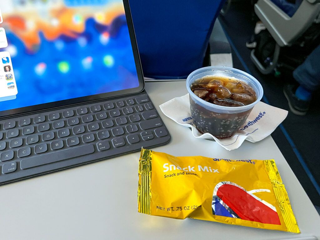 A drink and snack in front of a laptop on a Southwest Airlines flight