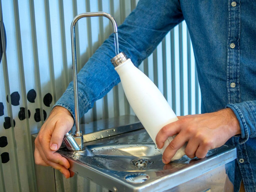 Man filling a reusable water bottle