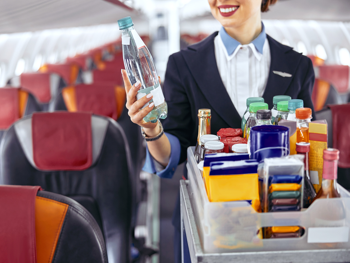 Stewardess holding water bottle in an airplane cabin