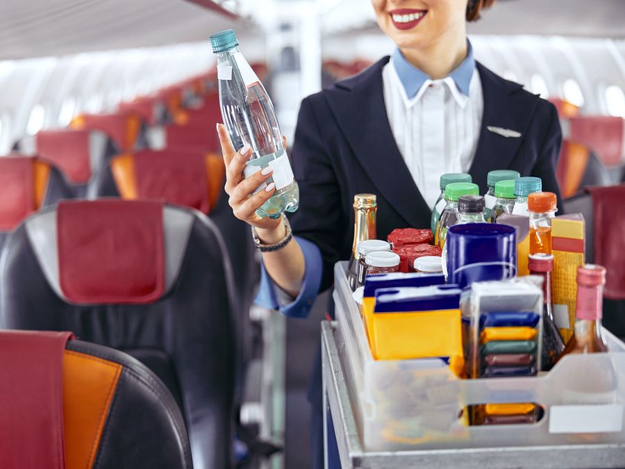 Stewardess holding water bottle in an airplane cabin