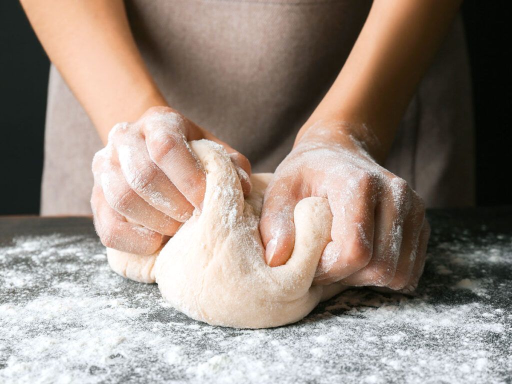 Woman rolling pizza dough