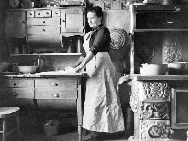 Woman cooking, circa 1909