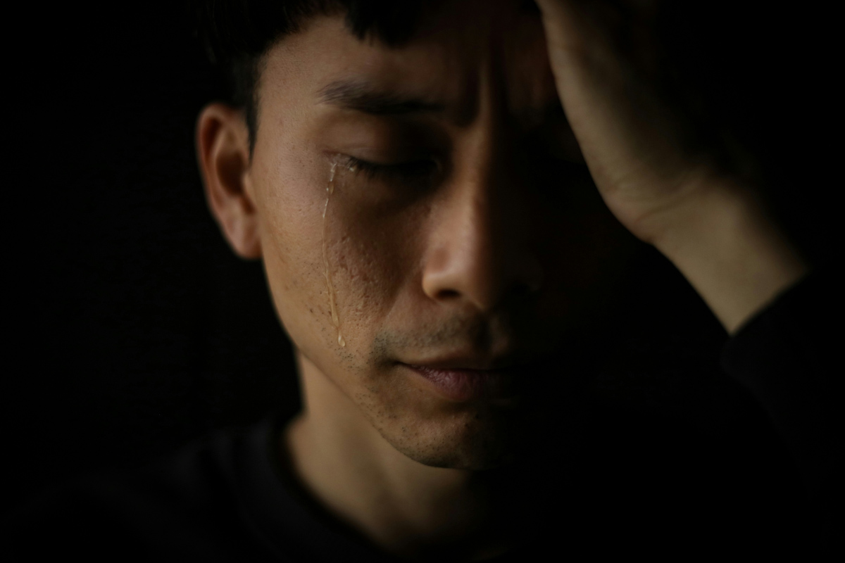 A close up moody image of a man crying