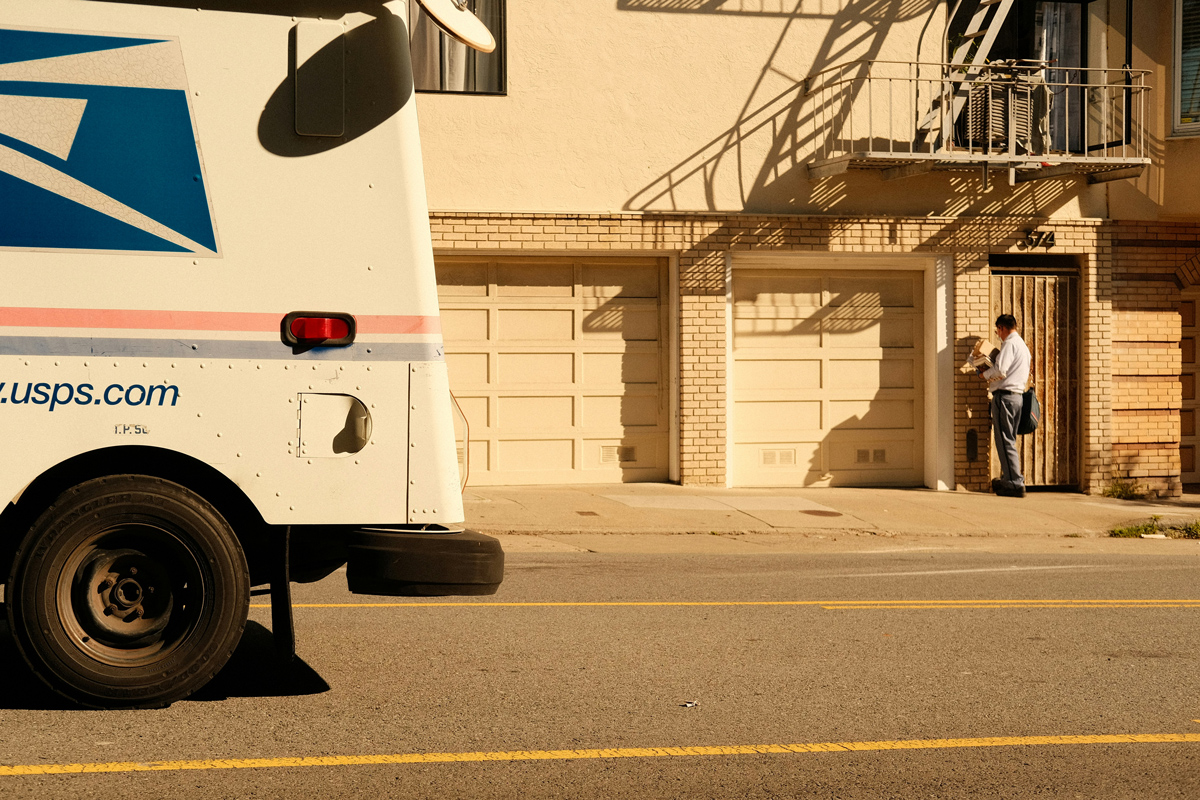 A close-up shot of the back tire and bumper of a U.S. mail truck