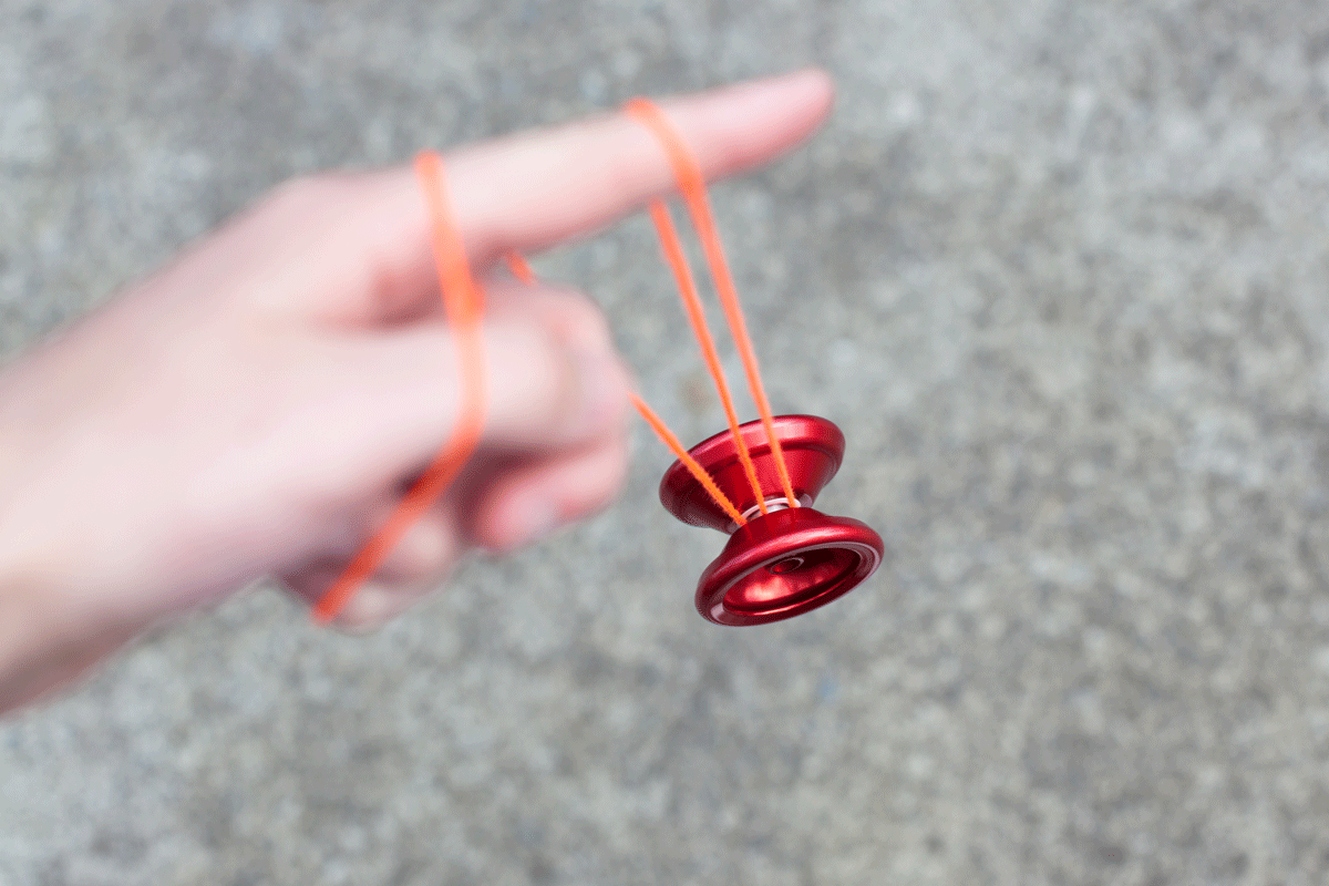 A red yo-yo wrapped around a user's finger