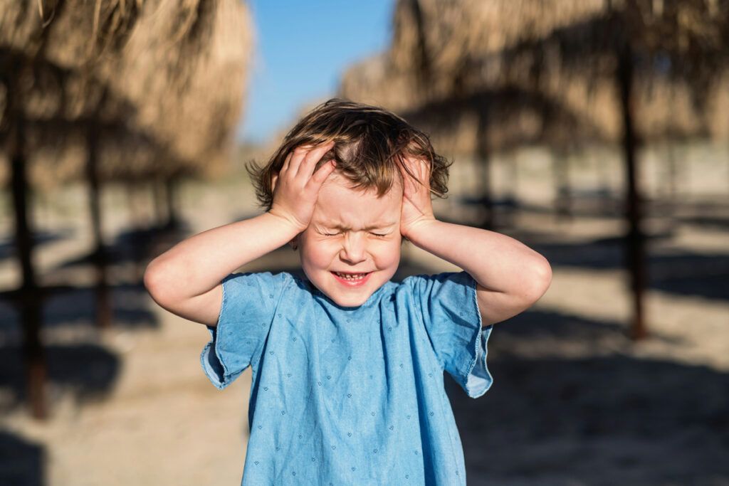 Child holding head in pain