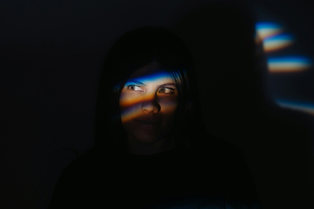 Person in the dark with light across their eyes
