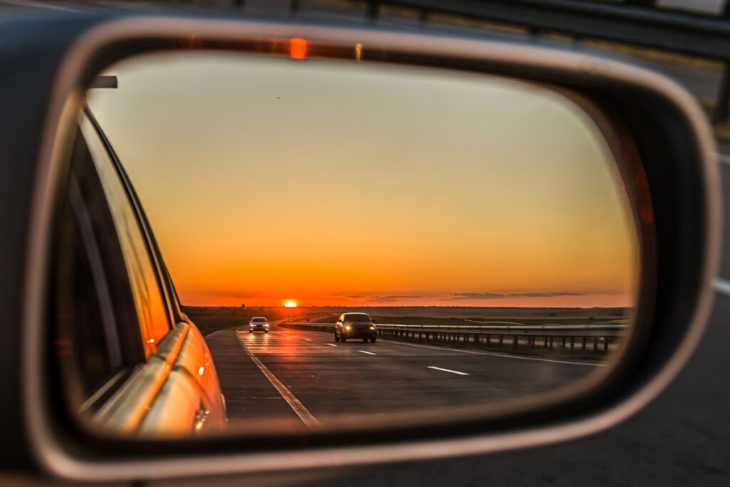 Sunset reflected in a passenger-side mirror