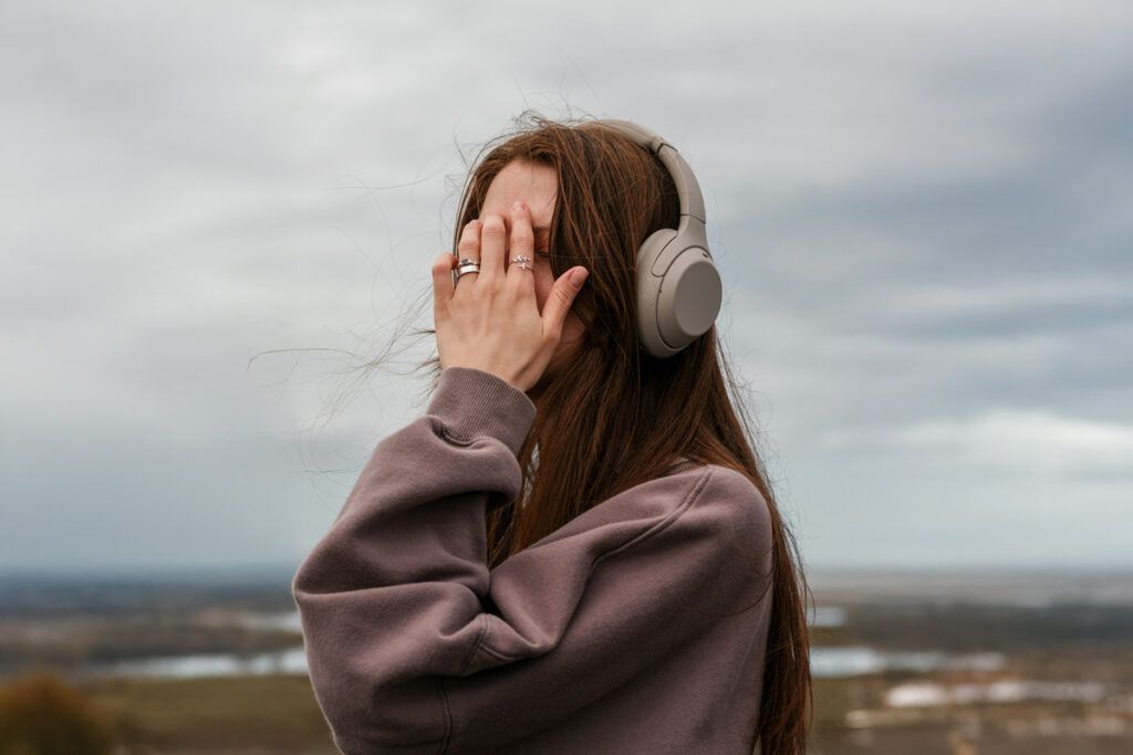Person covering their face while listening to music