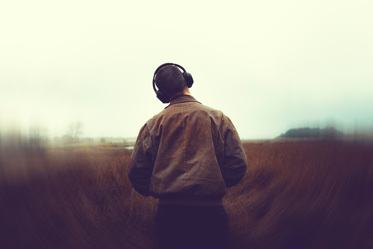 Person listening to music in a field