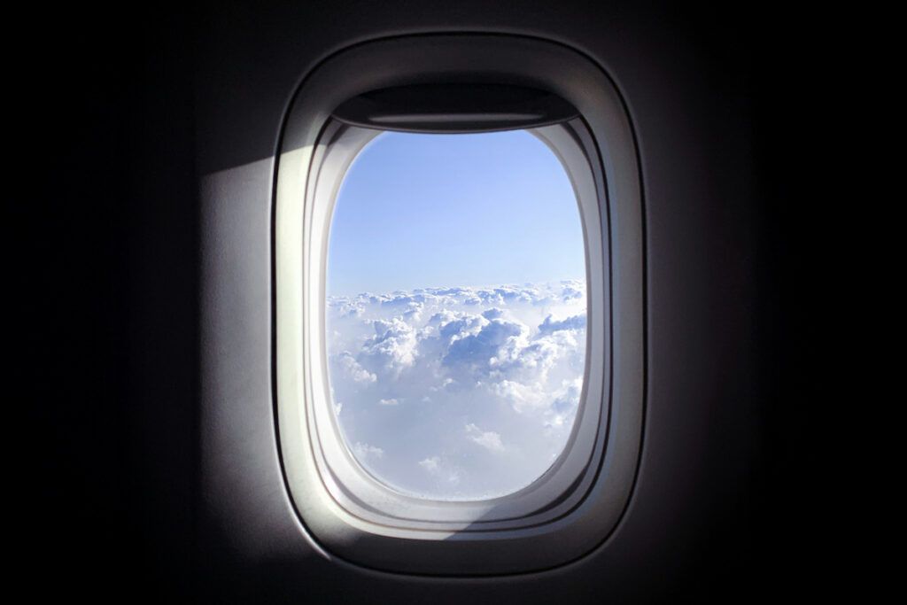 Airplane window looking out at clouds