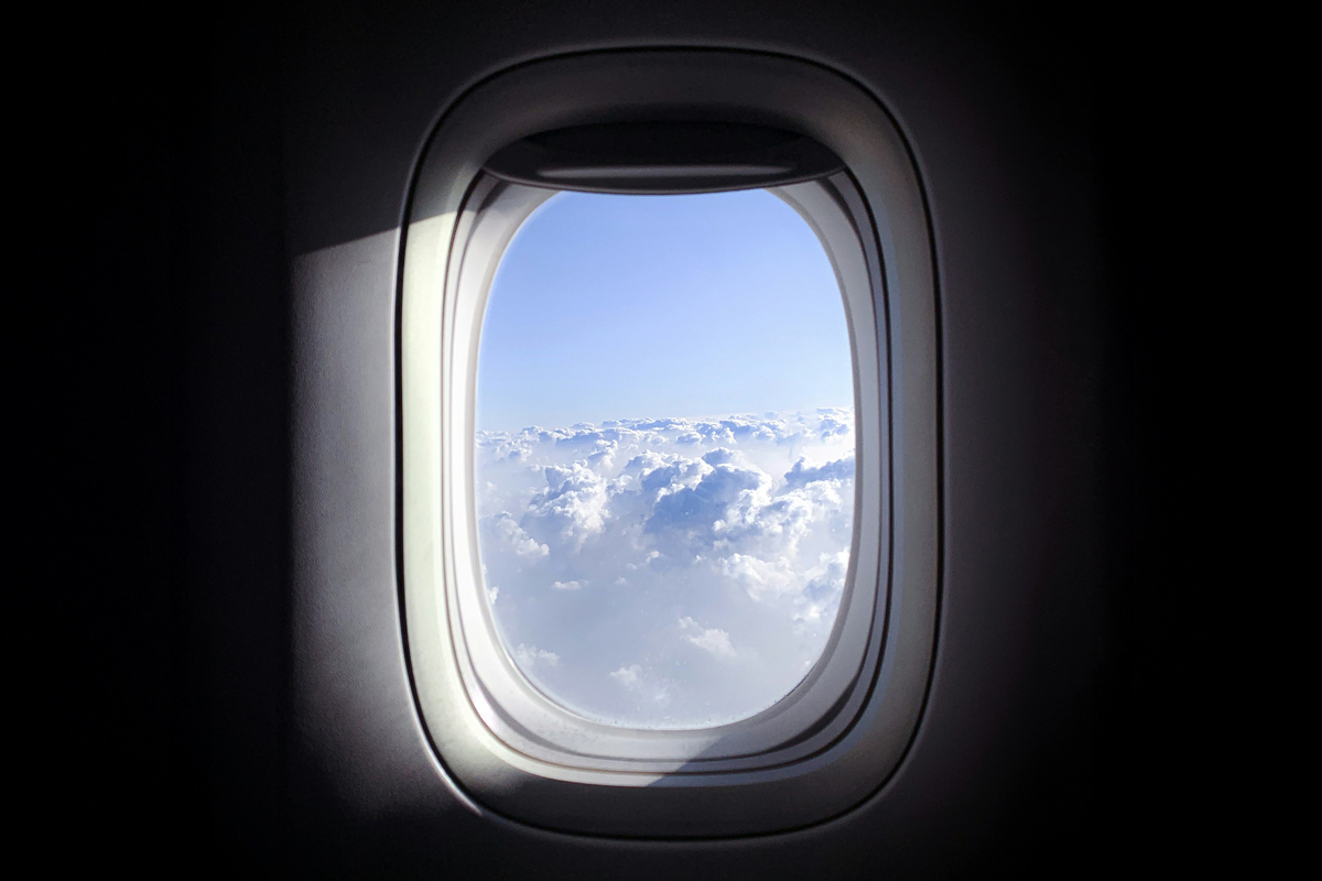 Airplane window looking out at clouds