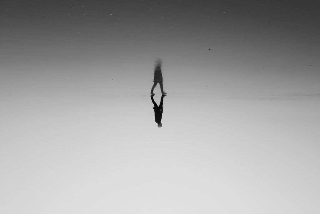 A person standing on top of their reflection