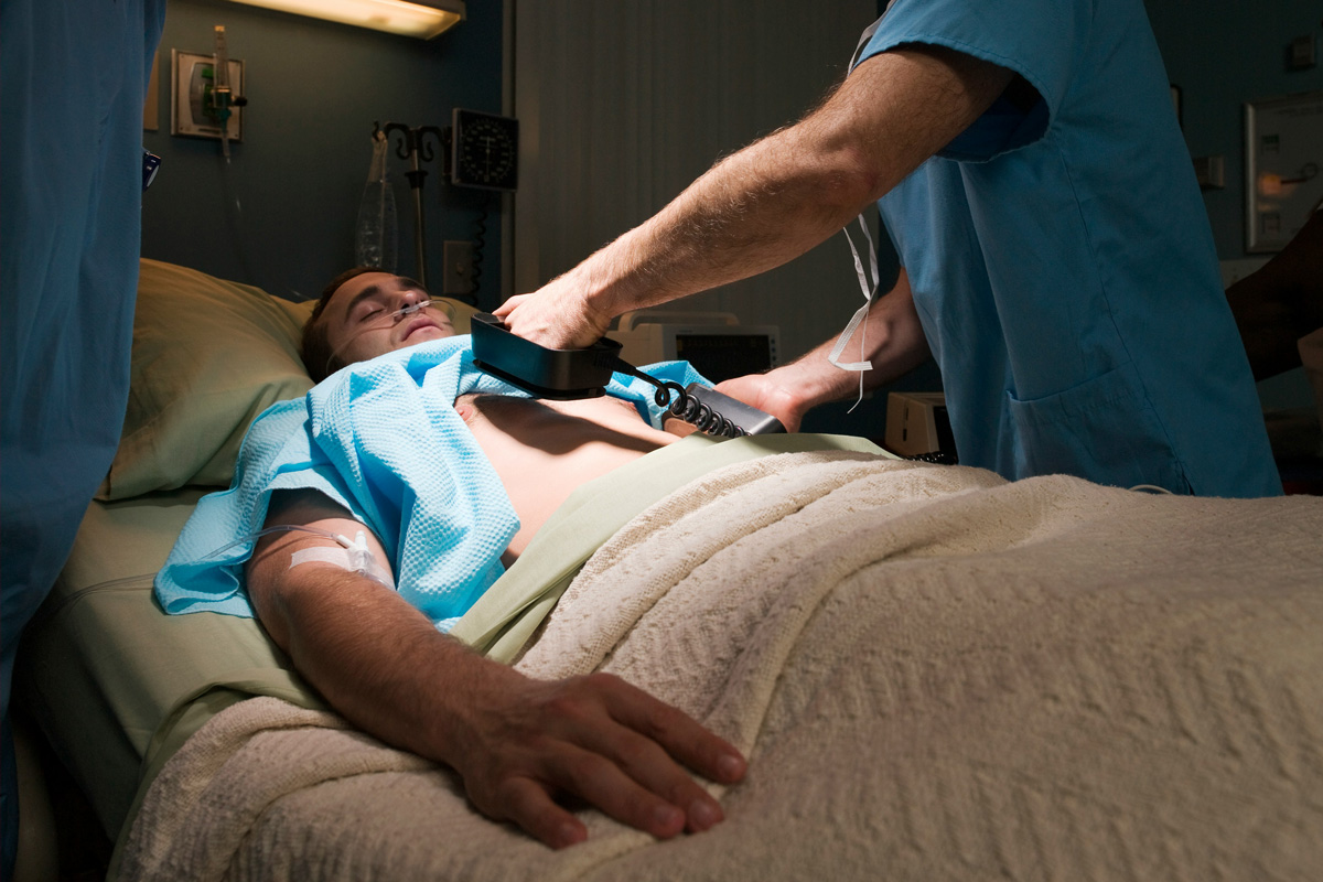 Doctor using a defibrillator on a patient
