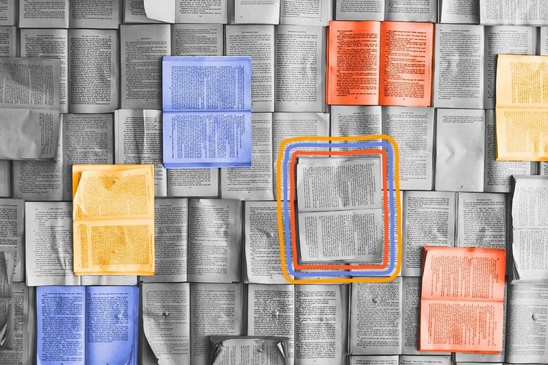 A variety of open books are displayed pages up