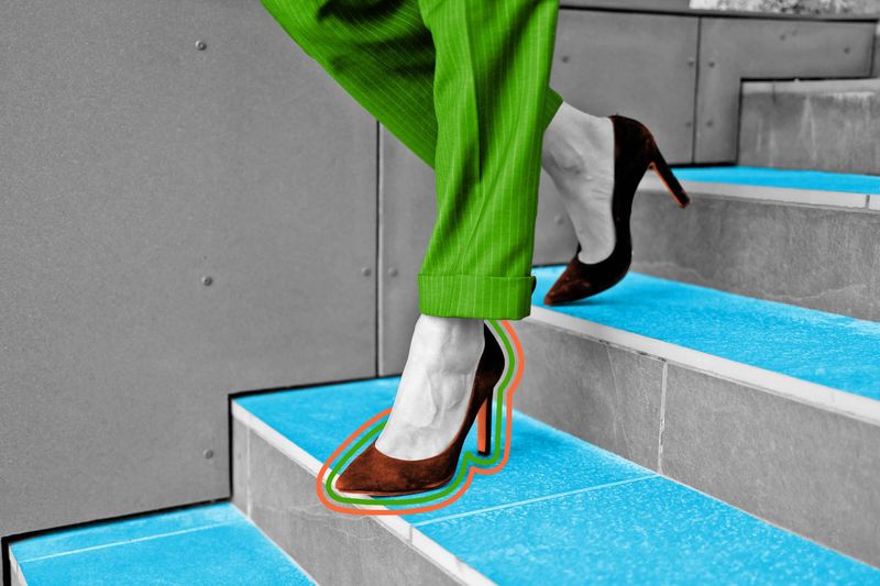 Close-up view of woman walking down the stairs in high heels