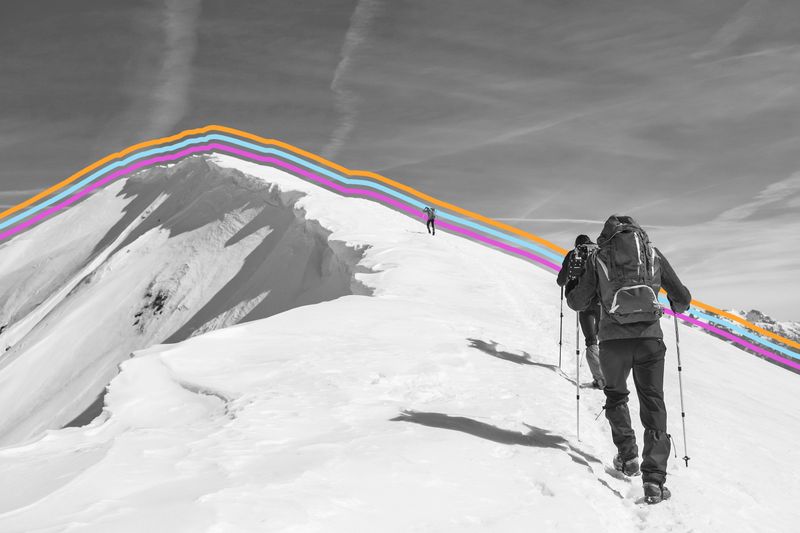 Hiker climbing the snowy peak of a mountain