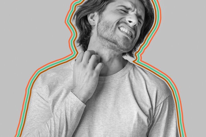 Uncomfortable man scratching at neck