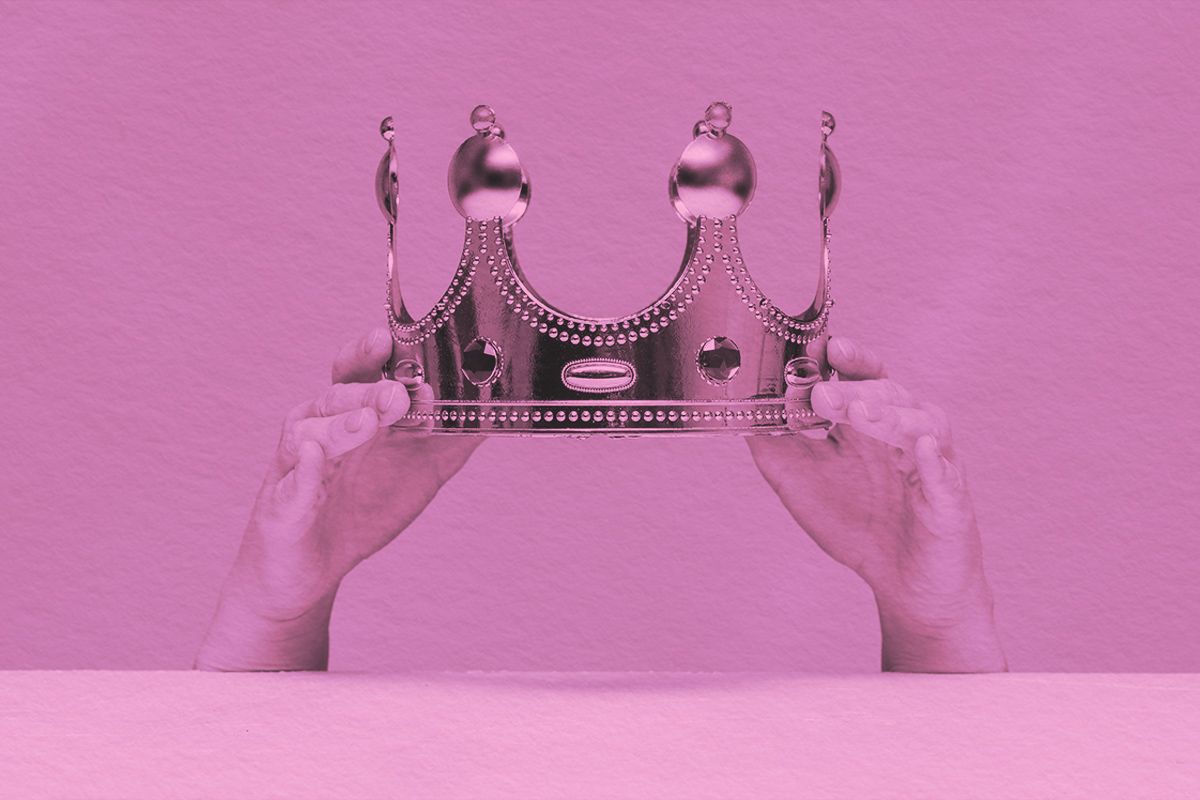 Crown in hands close up above a table