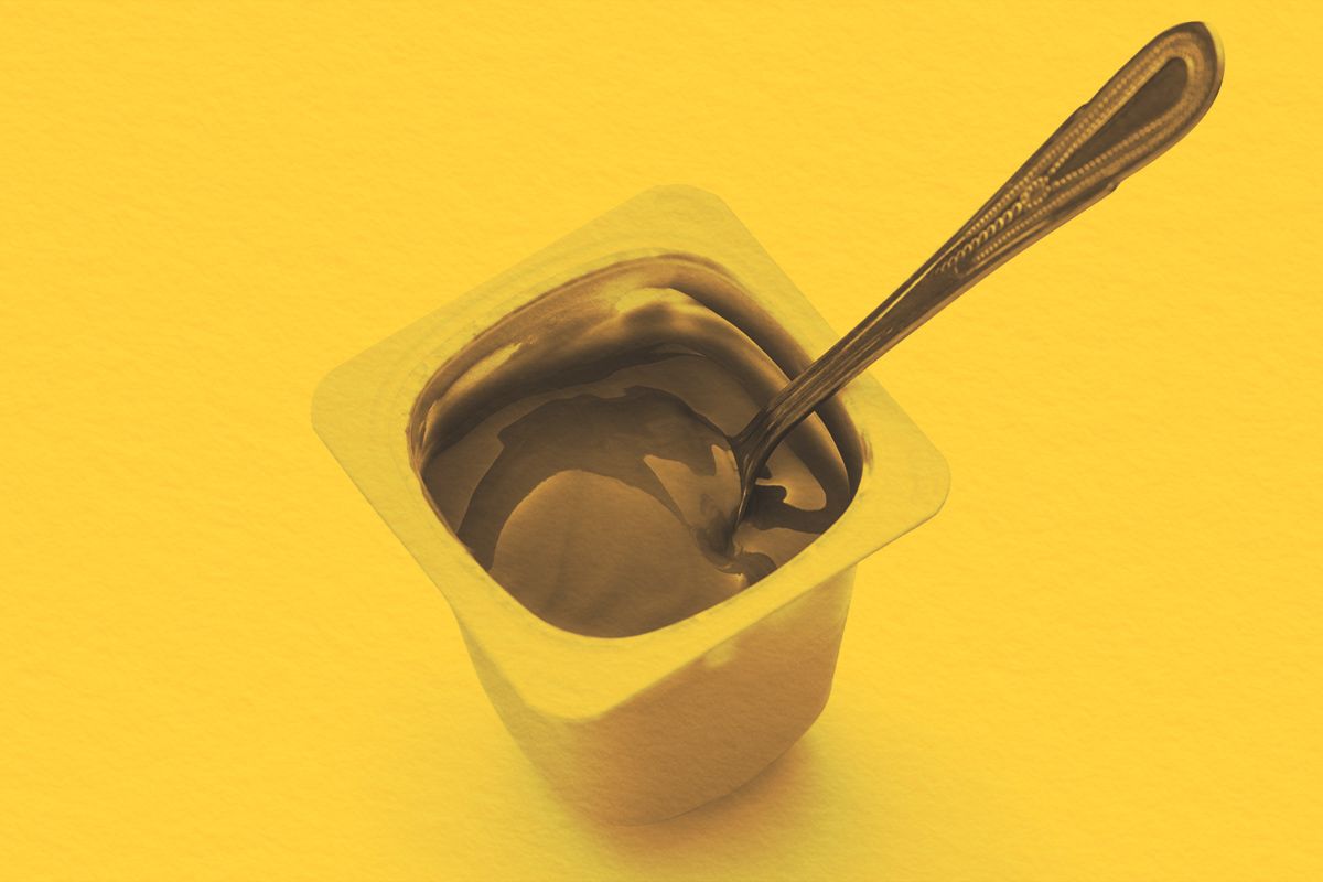 Open pudding cup with a metal spoon
