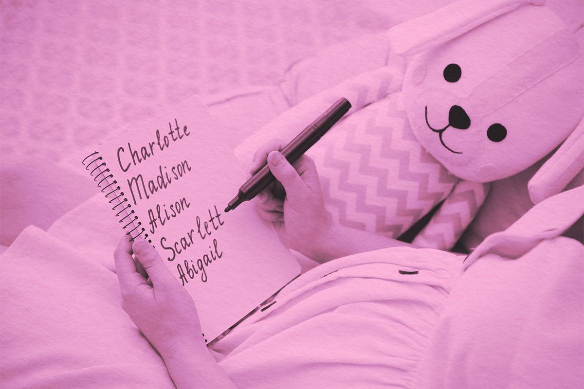 Pregnant woman with baby names list sitting in armchair