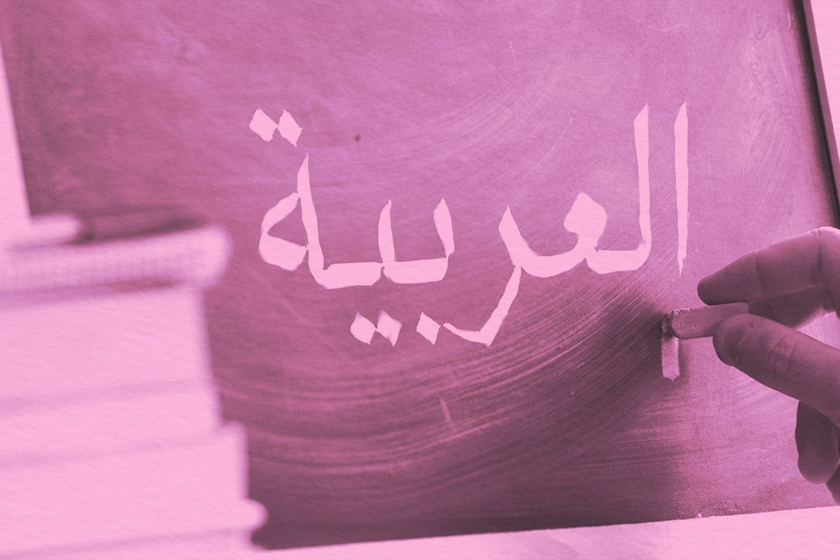 Hand writing on a blackboard in an Arabic class