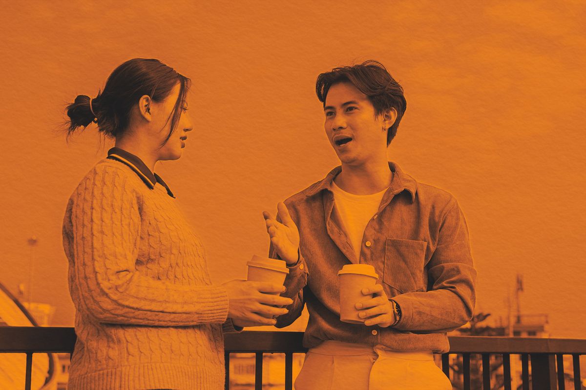 Two people engage in a conversation on a rooftop