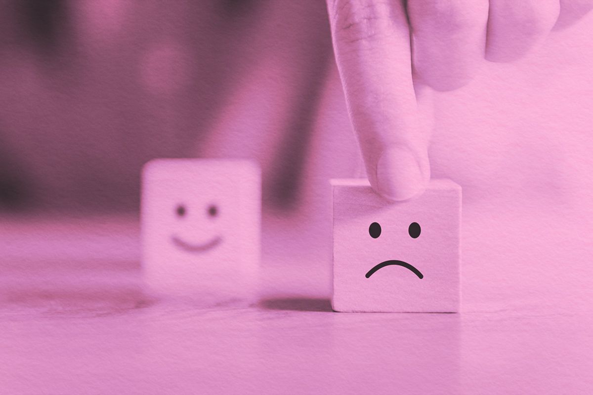 Happy face block in background, sad face block in foreground