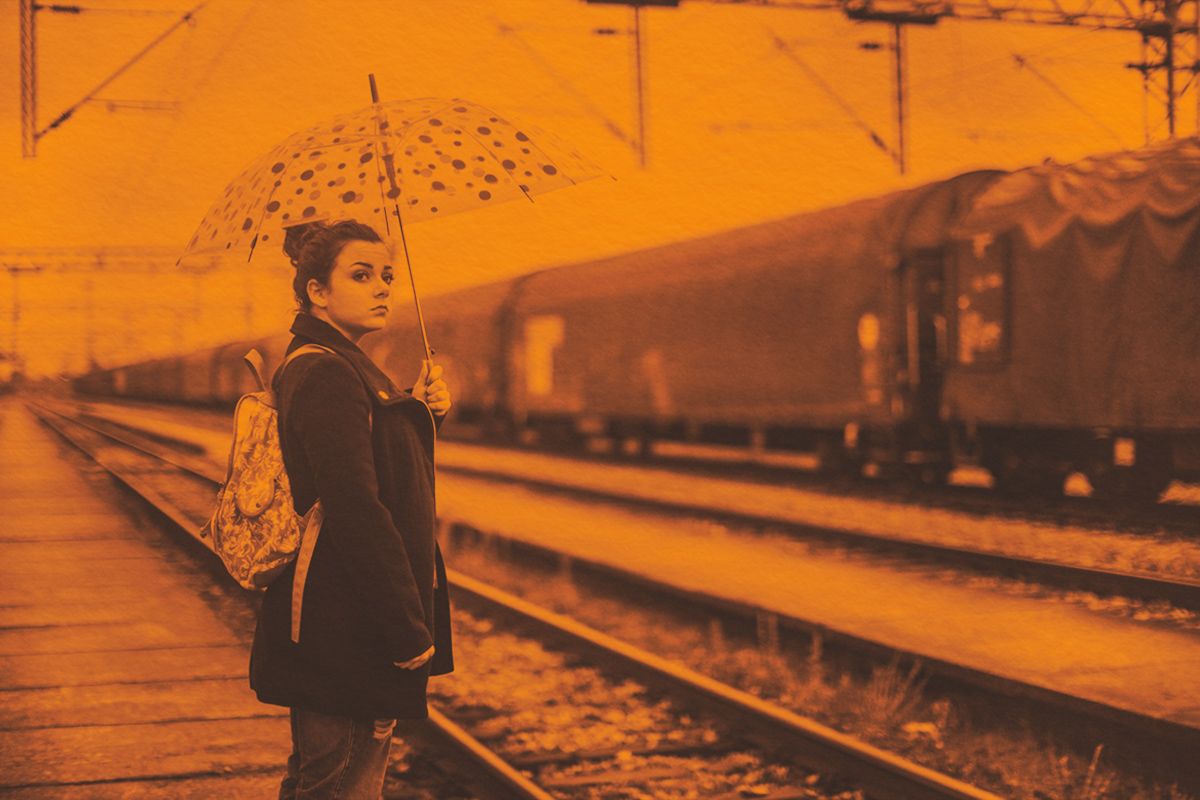 Woman waiting for train in the rain