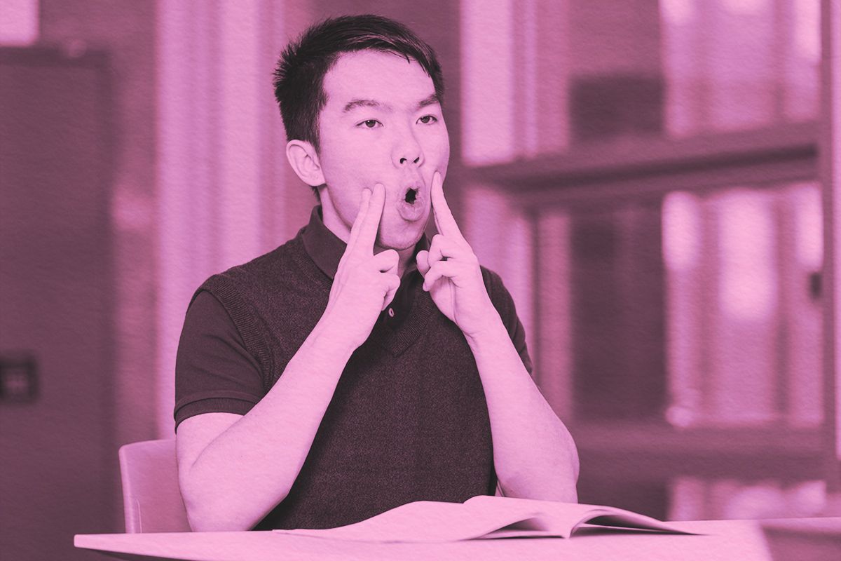A young teenage boy doing oral motor exercises