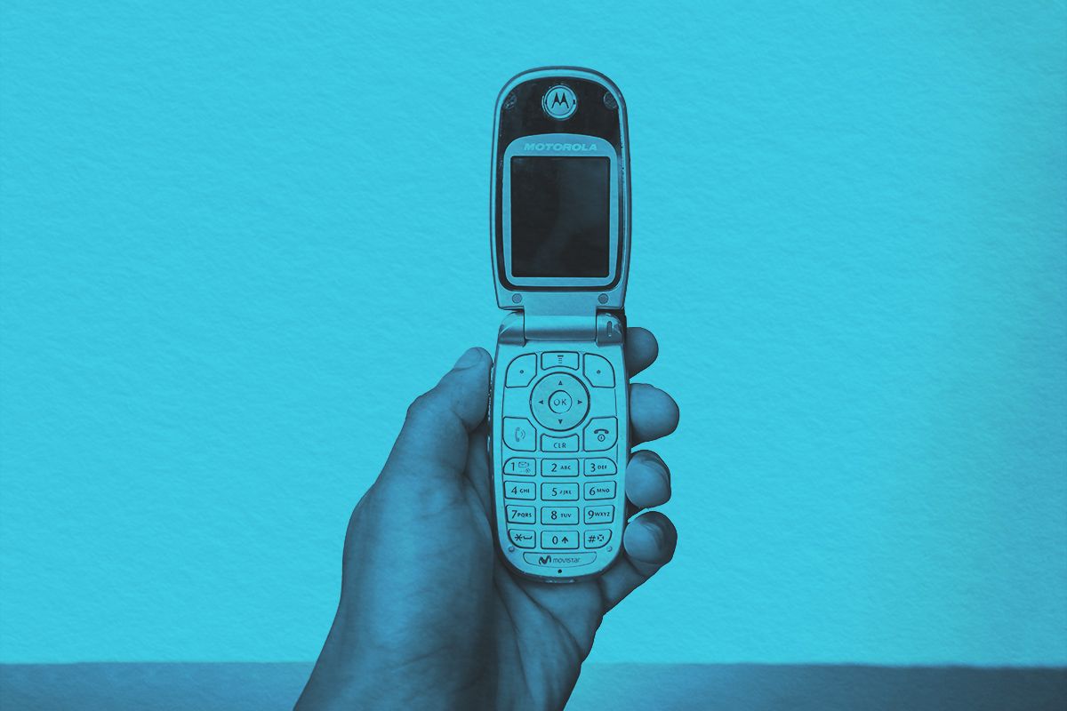 holding old flip phone